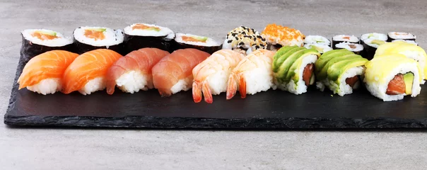 Fototapeten Nahaufnahme von Sashimi-Sushi-Set mit Stäbchen und Soja - Sushi-Rolle mit Lachs und Sushi-Rolle mit Räucheraal, selektiver Fokus. © beats_