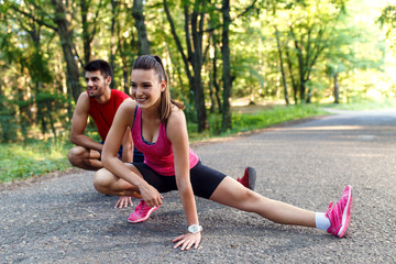 Young couple stretching his muscles outdoors before running.