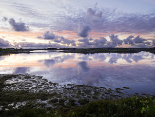 Cloudy sunset landscape on Atlantic road in Norway with the reflections in the sea water, white nights.