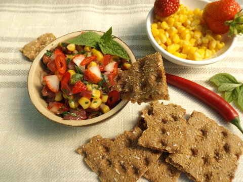 Salsa with strawberries and corn, dried rye bread. Mexican food.