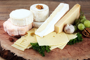 Cheese platter with different cheese on brown wooden plate