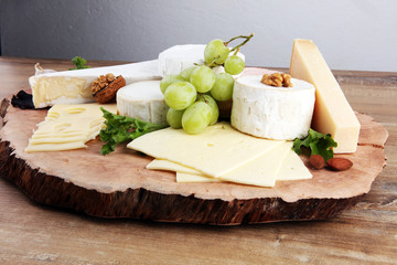 Cheese platter with different cheese on brown wooden plate