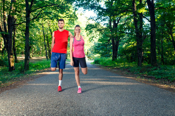 Young couple stretching his muscles outdoors before running.