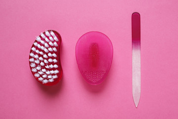 nail file, brush and rubber face cleaner on pink background