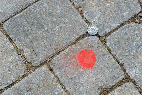 Messpunkt oder Vermessungspunkt zwischen Steinen