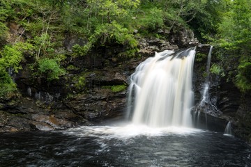 Fototapeta na wymiar Waterfall in rocks and trees