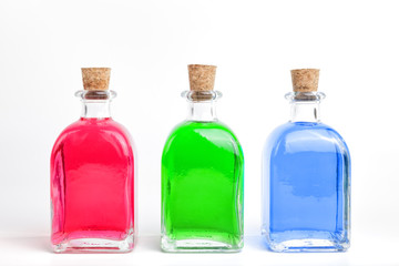Bottles of red, green, and blue liquid.