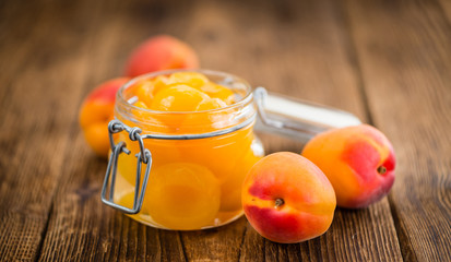 Preserved Apricots on wooden background (selective focus)