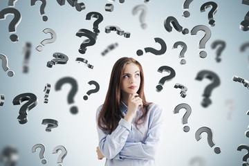 Pensive woman in a blue shirt, question marks