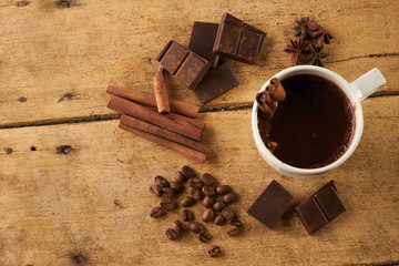 Closeup shot of freshly cup of coffee with cinnamon, coffee beans, cinnamon sticks anise and...