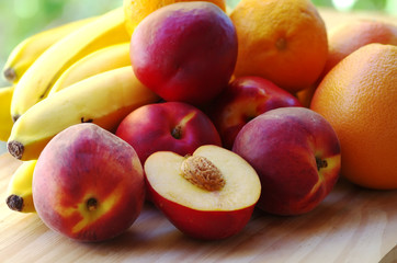 Fototapeta na wymiar ripe peaches. bananas and citrus fruits in table