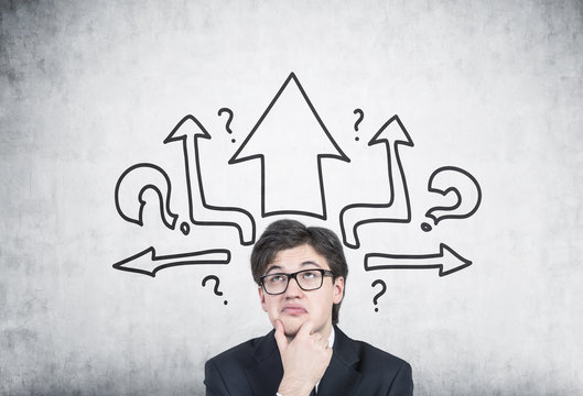 Pensive businessman in glasses, arrows, questions