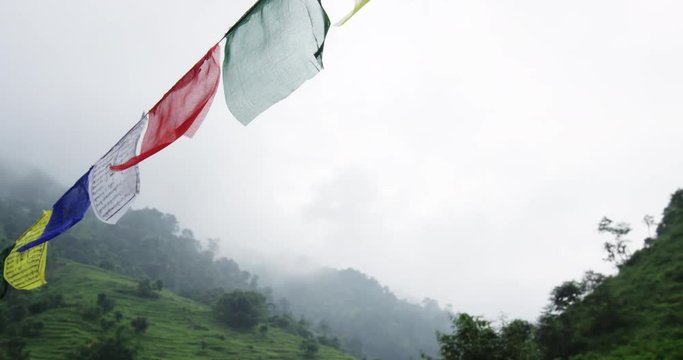 Nepal, flags hang near foggy mountain range