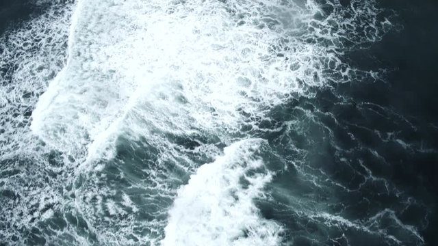 Waves break on water, overhead aerial