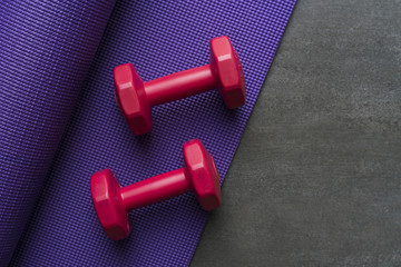 dumbbell and yoga mat on table, fitness healthy and sport concept