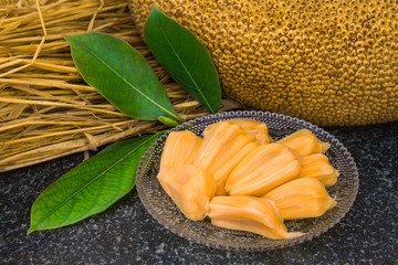 Fresh sweet jackfruit slices on a glass plate. Exotic ripe jackfruit ready for eat. Organic fruit concept. Tropical fruit. Selective focus.