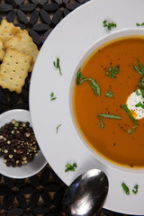 Tomato Soup Served in a Bowl with Basil and Sour Cream Garnish