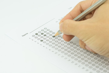 man hands filling in standardized test form