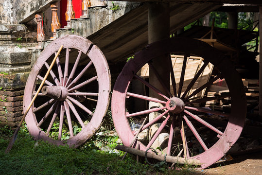 Old wooden wheels of the cart in temple, Thailand.