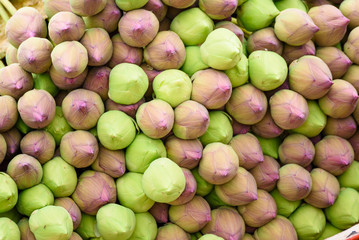 Stack of fresh unopened green and pink lotus buds waits for worshippers at the entrance to a Buddhist temple at Ratchaburi, Thailand.