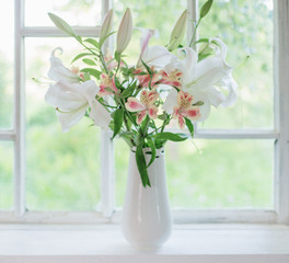 beautiful white lily in vase on windowsill