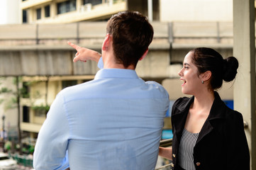 businessman and businesswoman talk about business outdoor, he Point the finger at some where and woman smile
