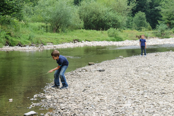 Fototapeta na wymiar Two boys near mountain river in Carpathians, Ukraine