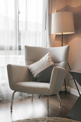 Modern classic style armchair with standing lamp at the corner of living room