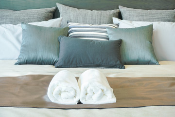 Fototapeta na wymiar White towels on bed in stylish bedroom interior