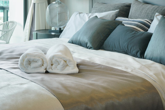 White towels on bed in stylish bedroom interior
