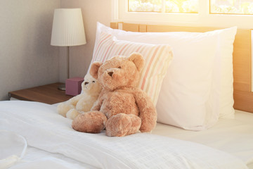 white bedroom decorative with pillows and dolls on bed in the morning