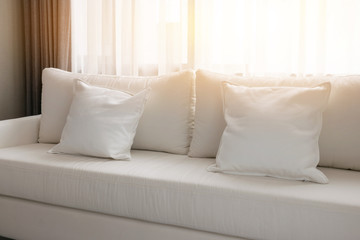 morning scene of white decorative pillows on a casual sofa in the living room