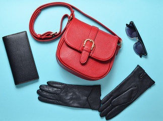 Leather stylish gloves, trendy red bag, purse, sunglasses. Accessories for lady. Top view.