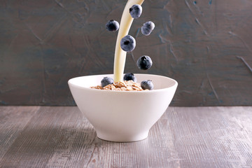 Oat flakes with falling blueberry and pouring milk