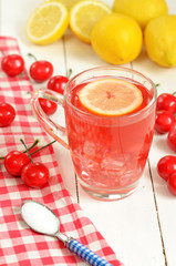Fruit cherry tea with slice of lemon in mug and cherries