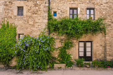 Fototapeta na wymiar Windows on a stone facade in old medieval town of Peratallada, Spain