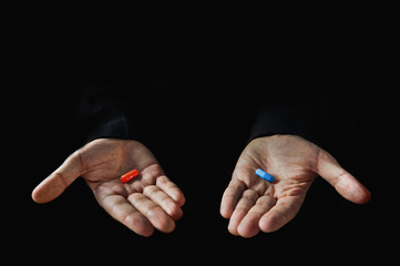 Red and blue pills on hand isolated