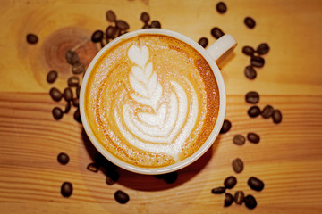 Cup of latte art on wooden table