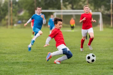 Fotobehang Kids soccer football - children players match on soccer field © Dusan Kostic