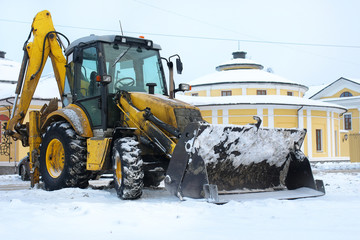 tractor for snow removal is parked on a city street