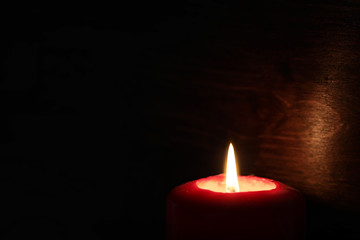 Burning candle flame in the dark