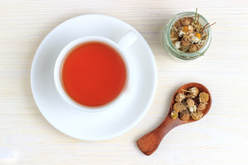 Obraz na płótnie Canvas Tea with chamomile in a jar and a wooden spoon