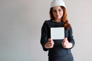 woman with a blank sheet of paper in his hand on construction site