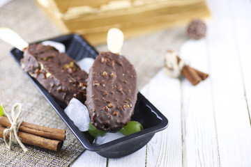 Dessert chocolate ice cream with nuts on wooden stick