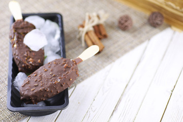 Dessert chocolate ice cream with nuts on wooden stick