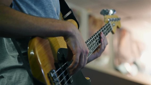 Musician Plays Rock Music On Electrical Bass Guitar. Slow Motion Effect
