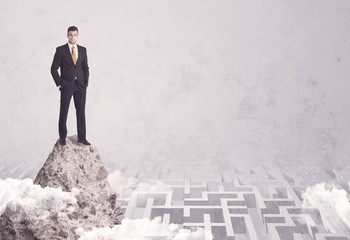 Businessman on cliff above labyrinth
