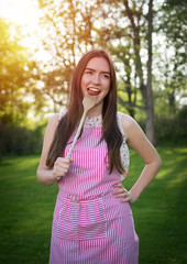 Young housewife with spoon in a natural environment