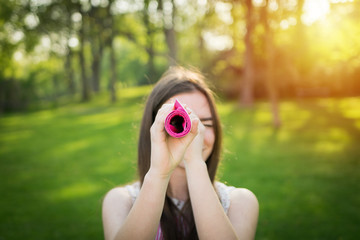 Young woman is looking through a rolled table-cloth