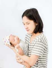 Portrait of a mother hugging her baby in hands and looking to her baby with love.